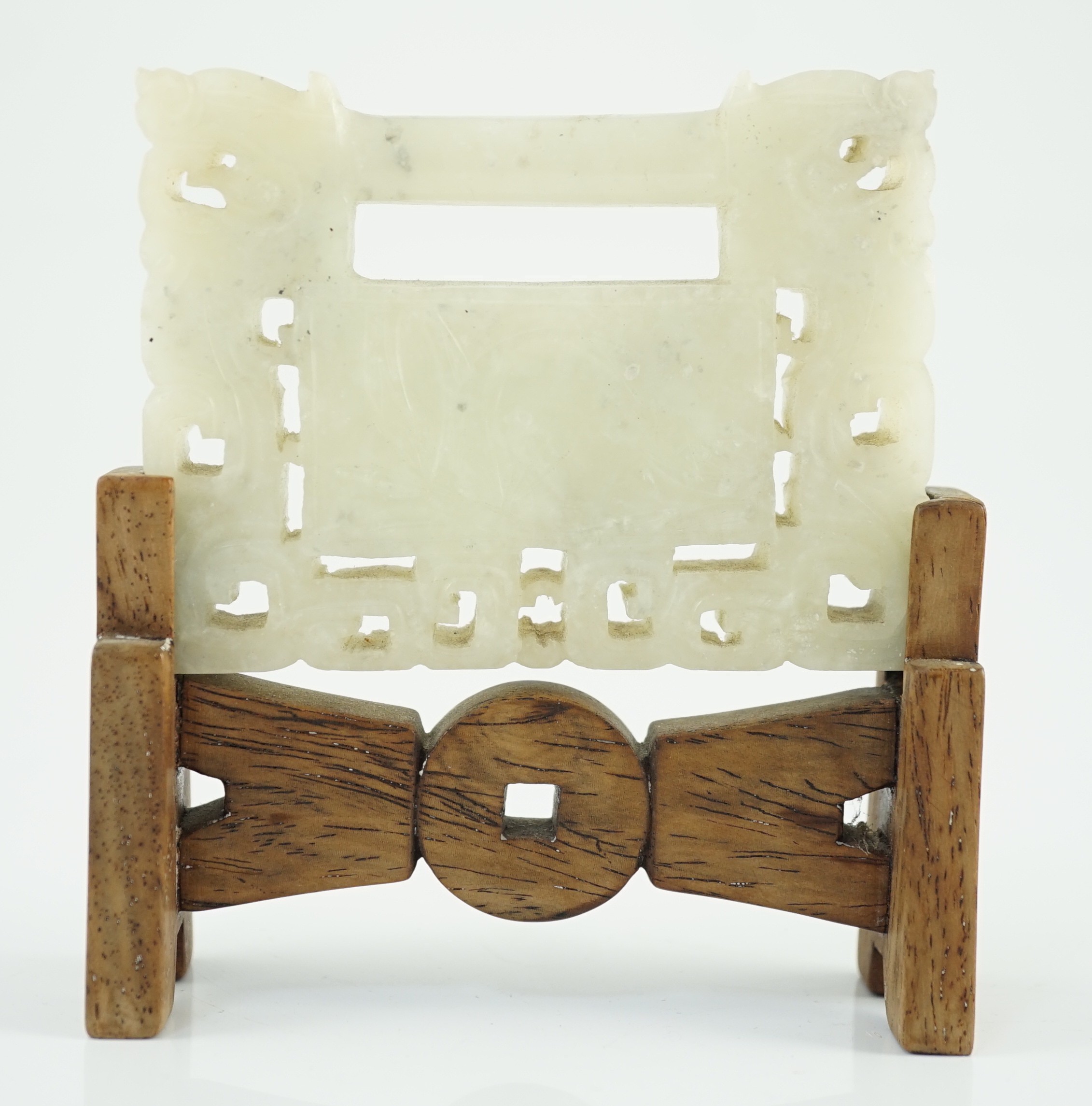 A Chinese speckled white jade ‘lock’ pendant plaque, 19th/20th century, 7.6cm x 5.8cm, wood stand